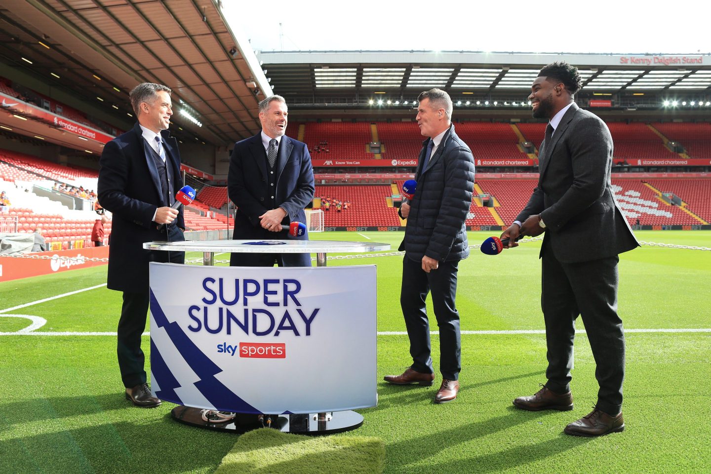 Sky Sports television presenter Dave Jones (L) stands pitchside with pundits Jamie Carragher (2L), Roy Keane (2R) and Micah Richards (R) before the Premier League match between Liverpool and Manchester City on October 3, 2021.