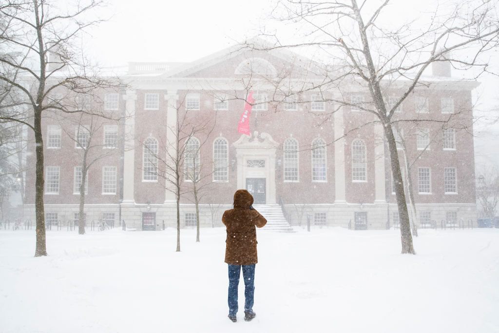 A man takes pictures of the snow on campus at Harvard University during a snowstorm, as seen in January 2022 in Cambridge, Massachusetts.
