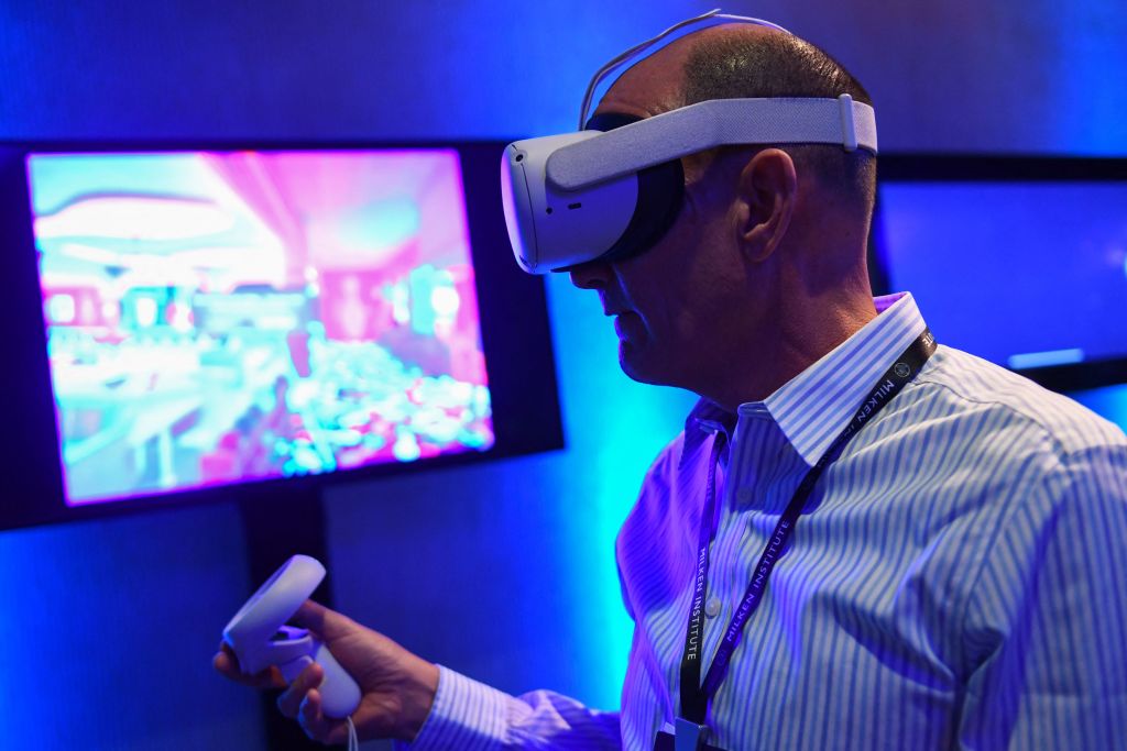Attendees use a virtual reality (VR) headset during a presentation from March Gaming during the Milken Institute Global Conference in Beverly Hills, California as seen in May 2022. (Photo by Patrick T. Fallon—AFP/Getty Images)