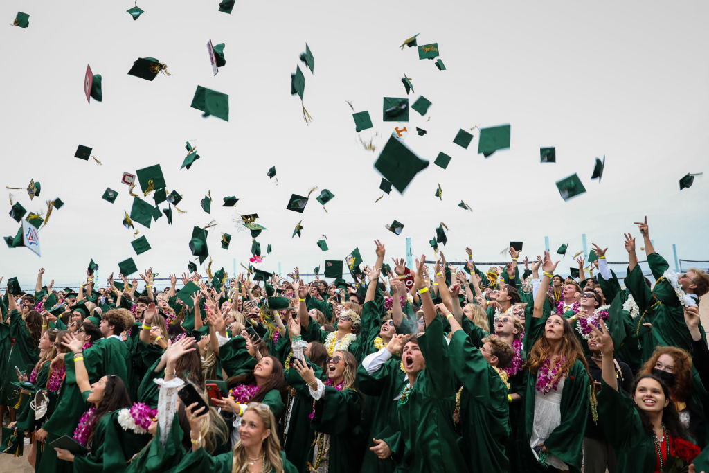 Mira Costa High School graduates toss their caps into the air next to the Manhattan Beach Pier, after taking part in an annual tradition of walking along The Strand from Hemosa Beach, to Manhattan Beach, CA, following their graduation ceremony, as seen in June 2022. (Jay L. Clendenin—Los Angeles Times/Getty Images)