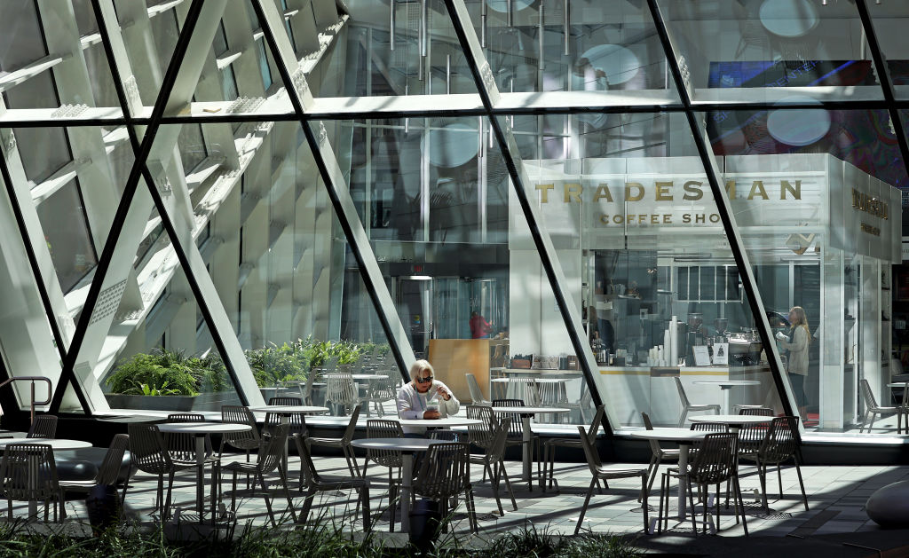 A woman eats by herself during lunchtime at a patio outside of 100 Federal Boston, as seen in August 2022. (Photo by David L. Ryan—The Boston Globe/Getty Images)