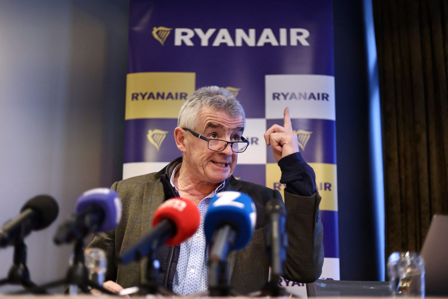A picture of Michael O'Leary speaking behind a row of microphones