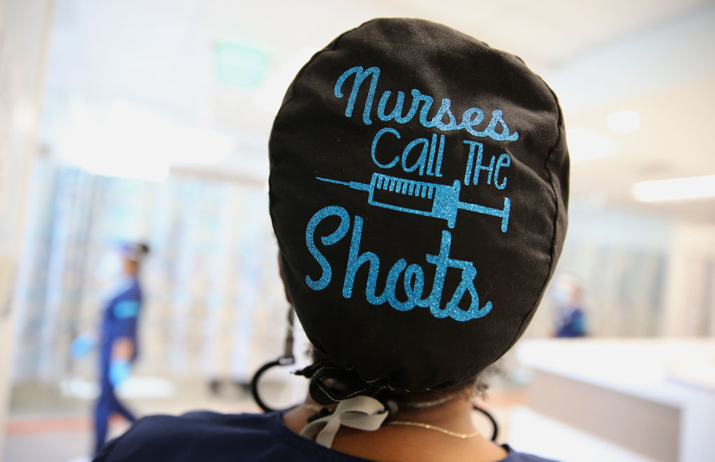 Photo of a scrub cap with lettering that reads, “Nurses call the shots.”