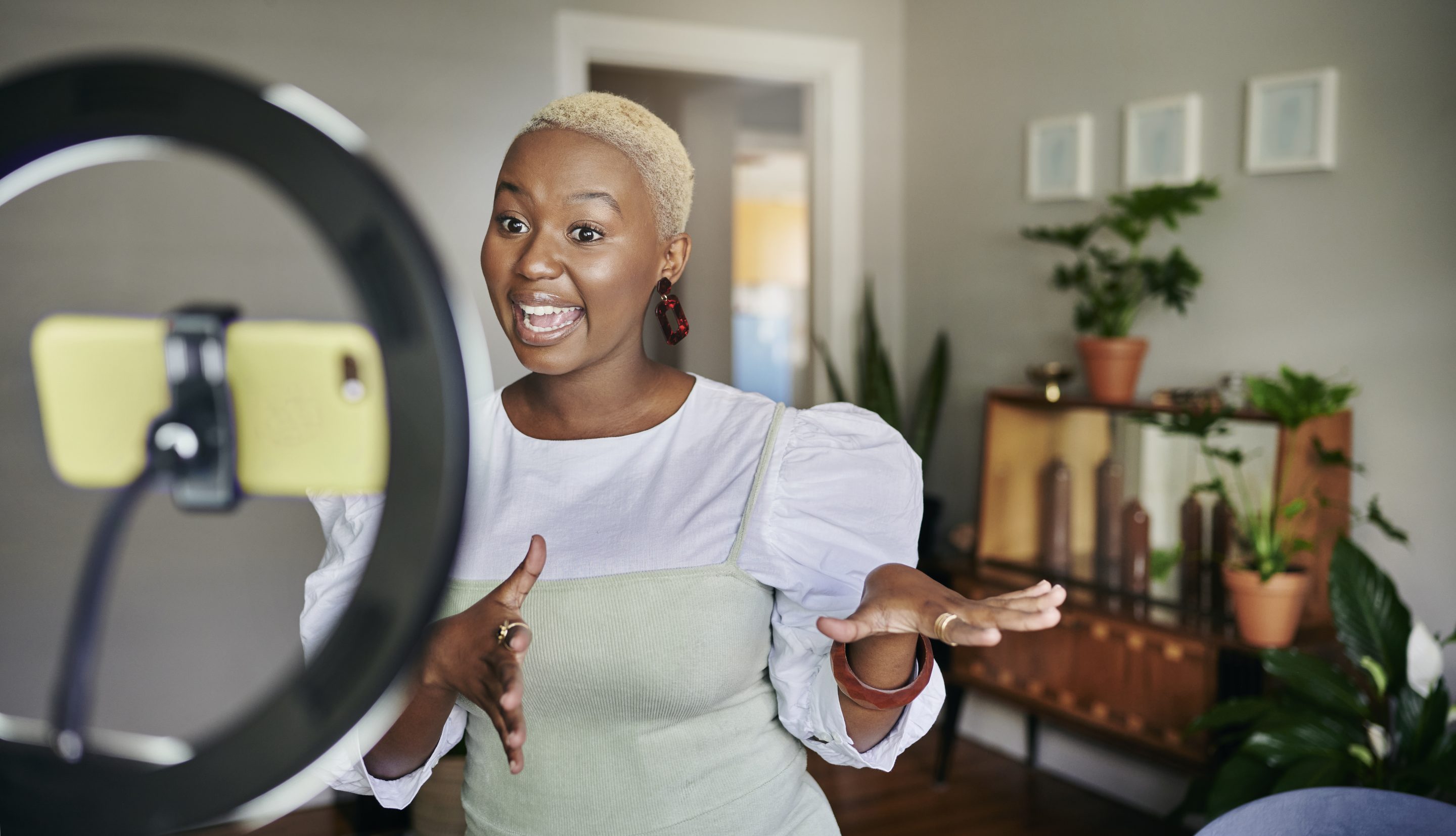Young woman in her home making a video of herself