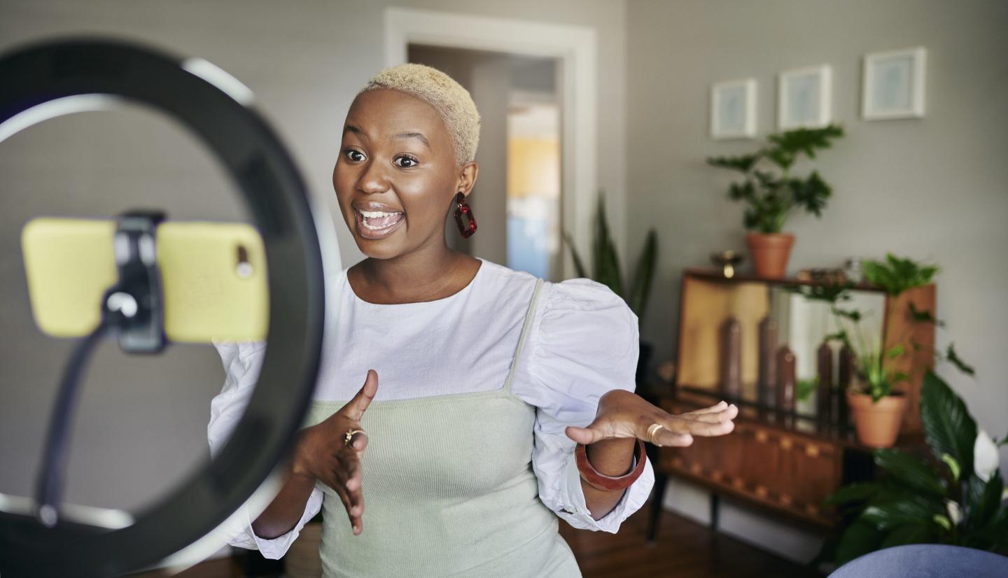 Young woman in her home making a video of herself