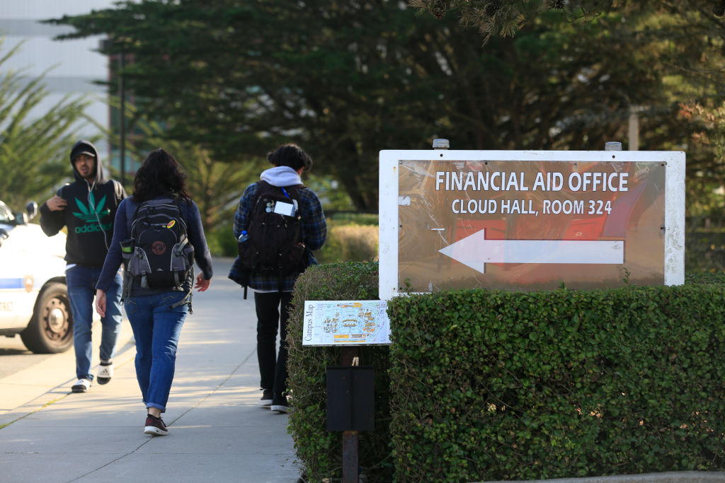 People walk past a directional sign for the financial aid office at City College of San Francisco, as seen in December 2017. (Photo By Lea Suzuki—The San Francisco Chronicle/Getty Images)