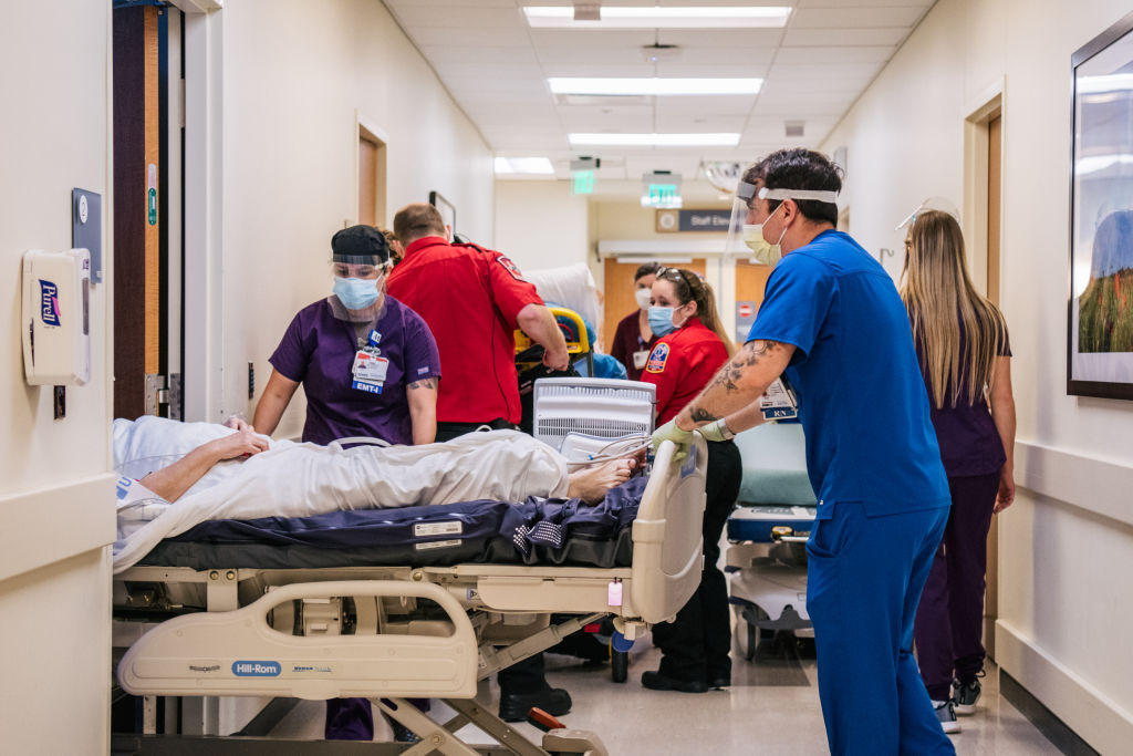 Emergency Room nurses and EMTs tend to patients in hallways at the Houston Methodist The Woodlands Hospital, as seen in August 2021 in Houston, Texas. (Photo by Brandon Bell/Getty Images)