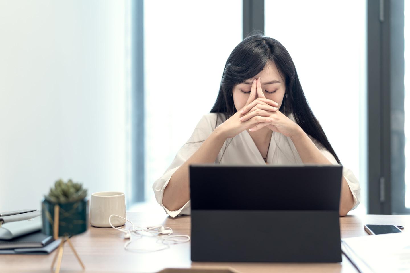 Stressed-looking businesswoman in front of her laptop screen