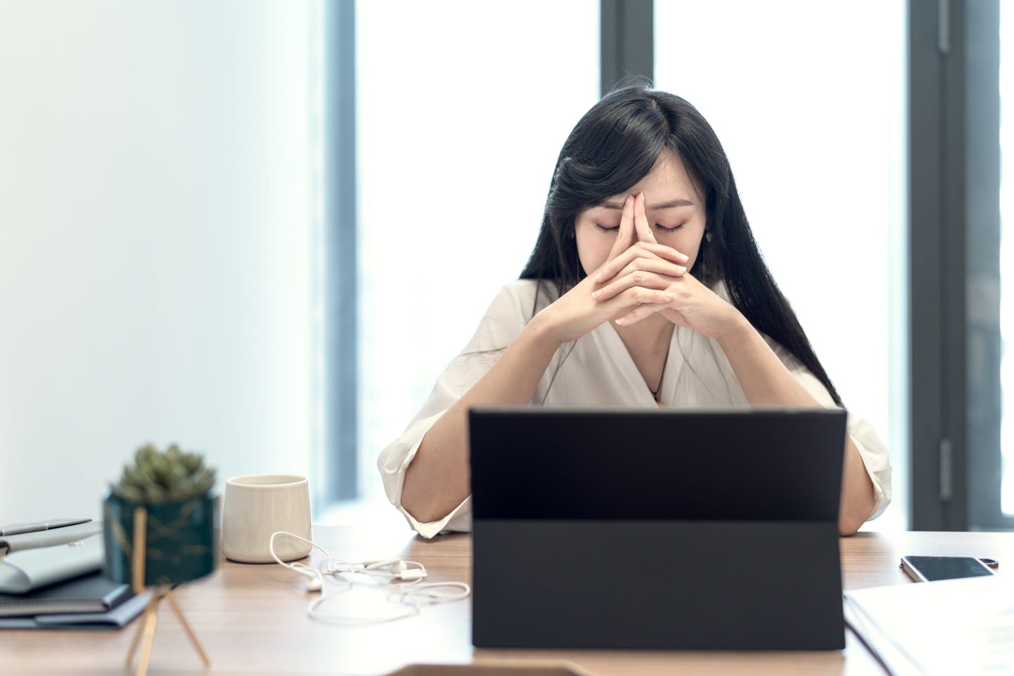 Stressed-looking businesswoman in front of her laptop screen