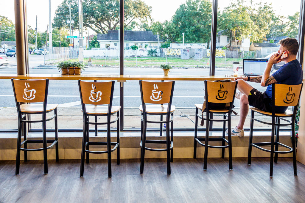 A customer on phone seated in window of a cafe in Orlando, Florida, as seen in December 2021. (Photo by Jeffrey Greenberg—UCG/Universal Images Group/Getty Images)
