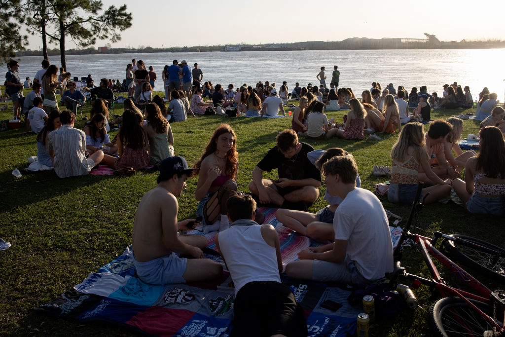 Students from Tulane University spend a Friday evening in March 2022 socializing on the banks of the Mississippi River in New Orleans. (Andrew Lichtenstein—Corbis/Getty Images)