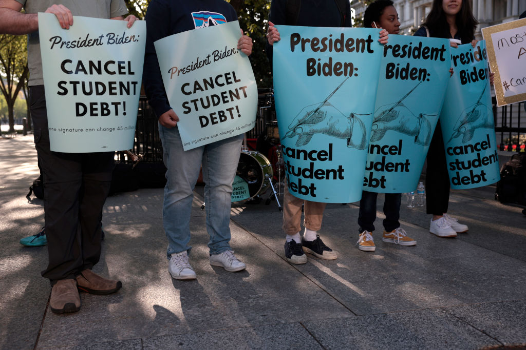 Activists hold signs as they attend a Student Loan Forgiveness rally on Pennsylvania Avenue and 17th street near the White House, as seen in April 2022 in Washington, D.C. (Photo by Anna Moneymaker/Getty Images)