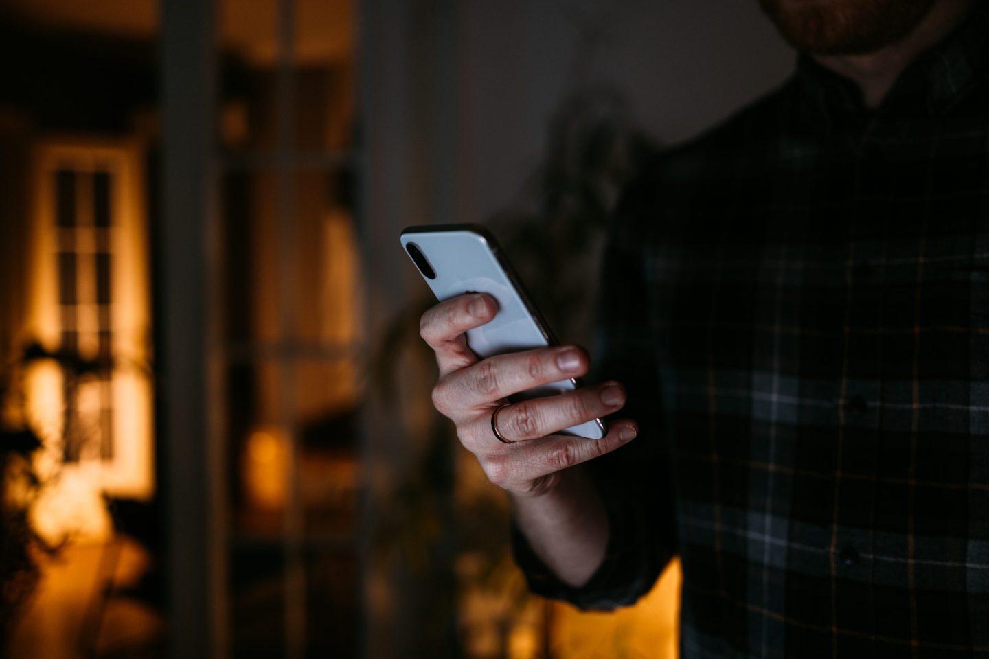 A man looking at his phone in a dark setting