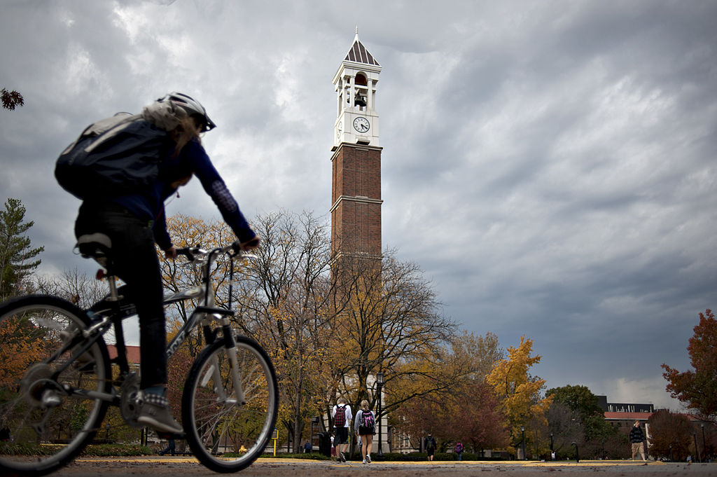 A student rides a bicycle past the bell tower on the campus of Purdue University in West Lafayette, Ind., as seen in October 2012. (Photographer: Daniel Acker—Bloomberg/Getty Images)