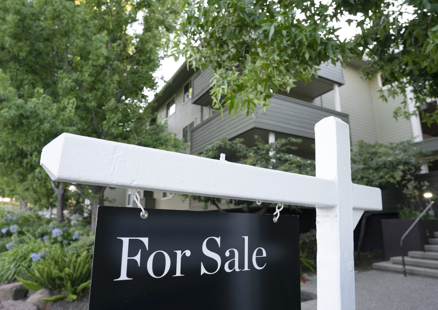 A for-sale sign hangs in front of a home in San Mateo County, California