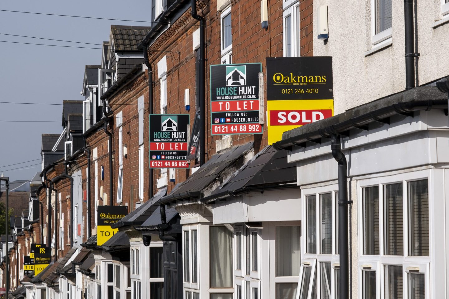 a row of houses with signs showing sold or to let signs