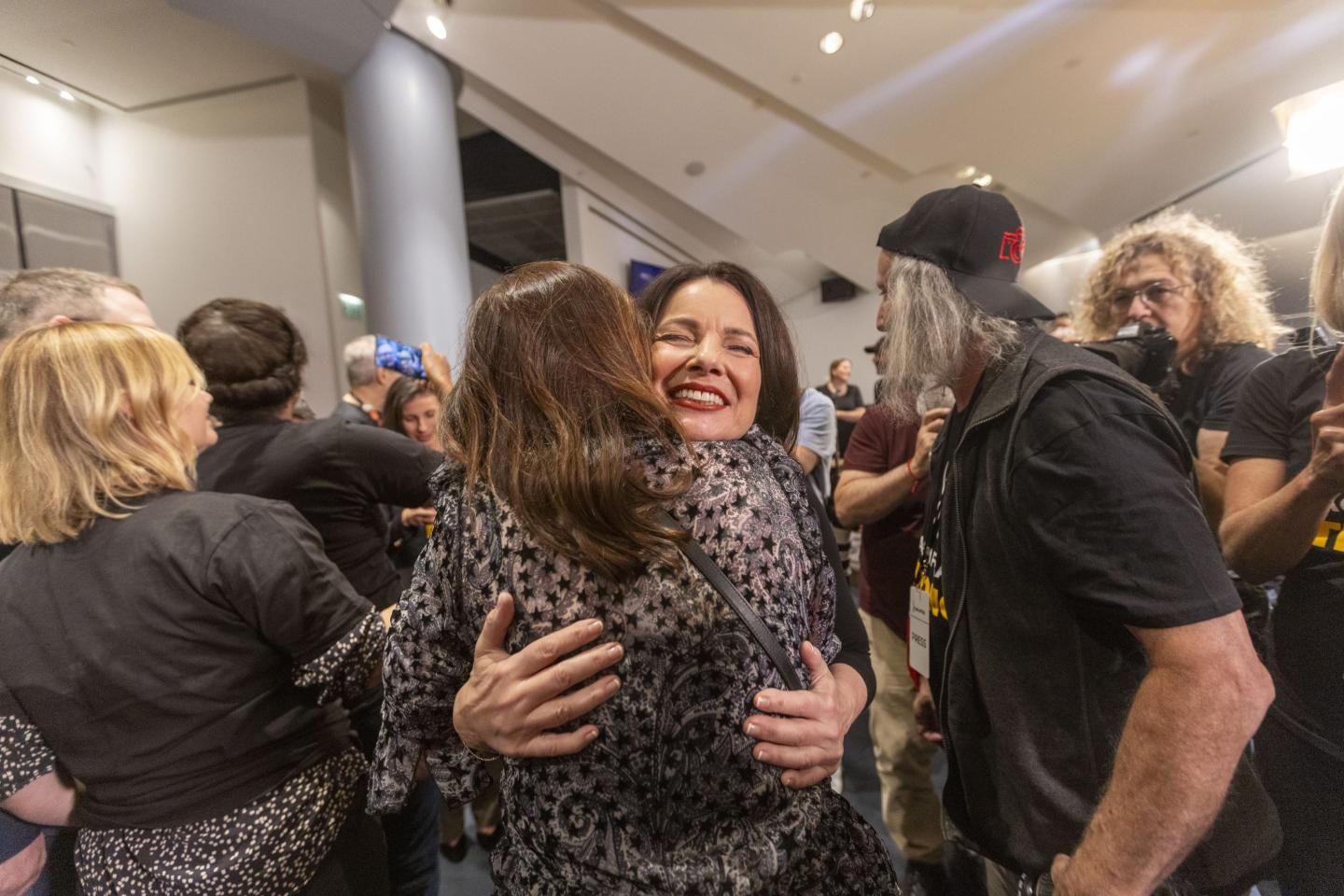 Fran Drescher, president of SAG-AFTRA, center, hugs colleagues during a news conference