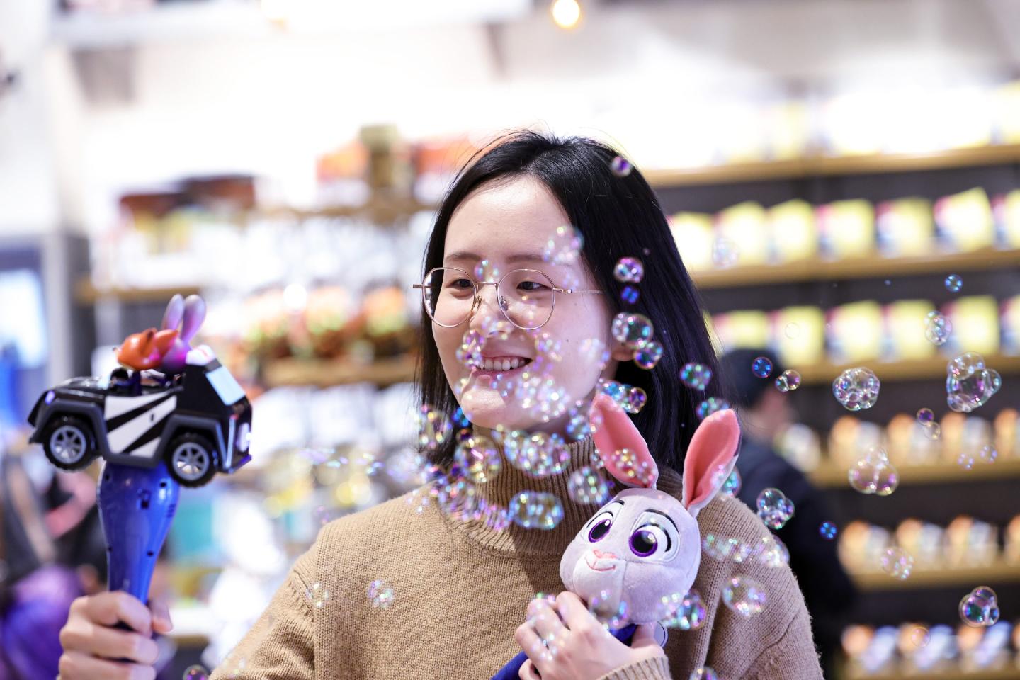 A woman holding a toy while taking a selfie
