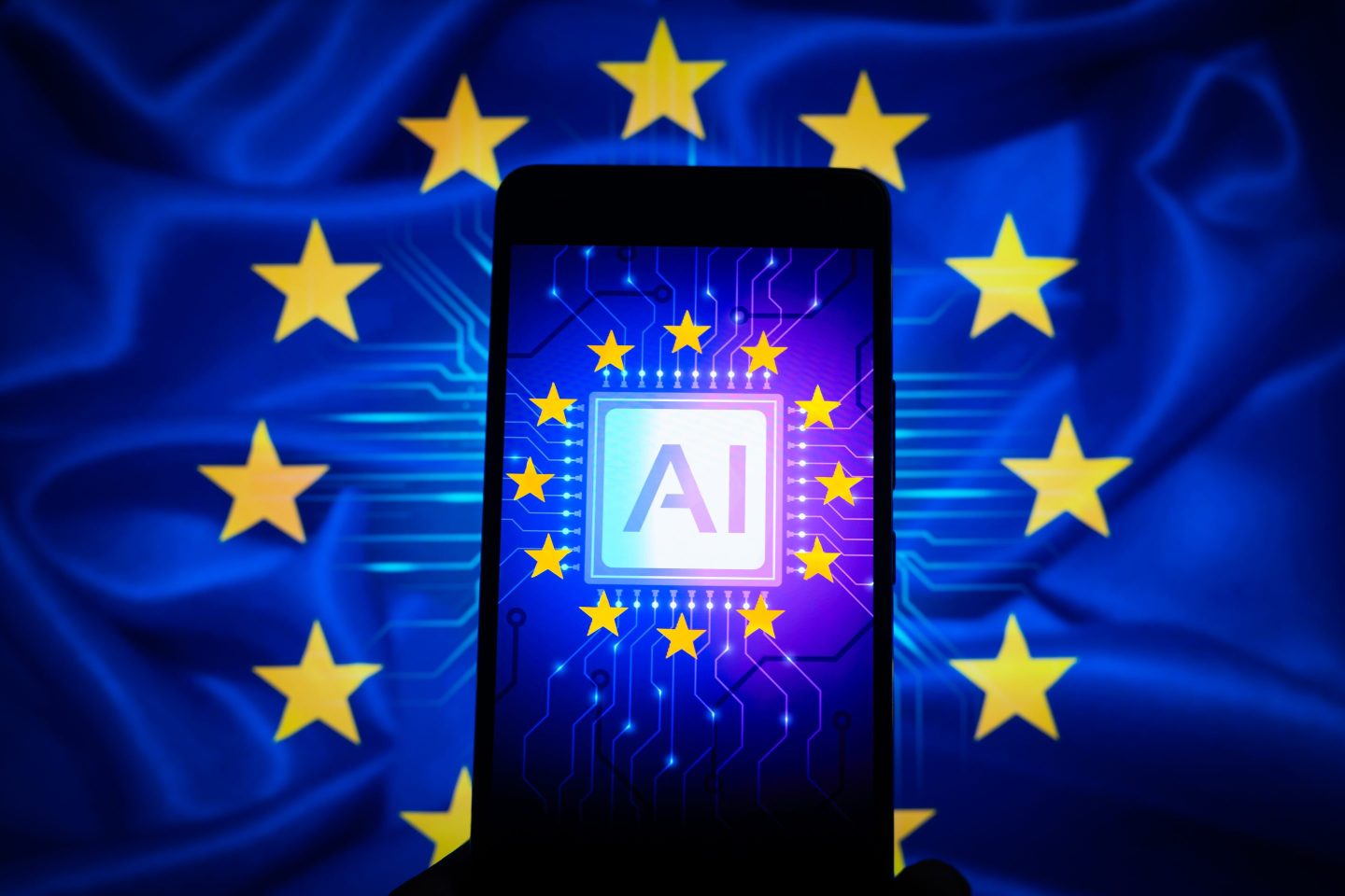 An icon representing Artificial Intelligence is being displayed on a smartphone, with AI and EU stars visible in the background, in this photo illustration