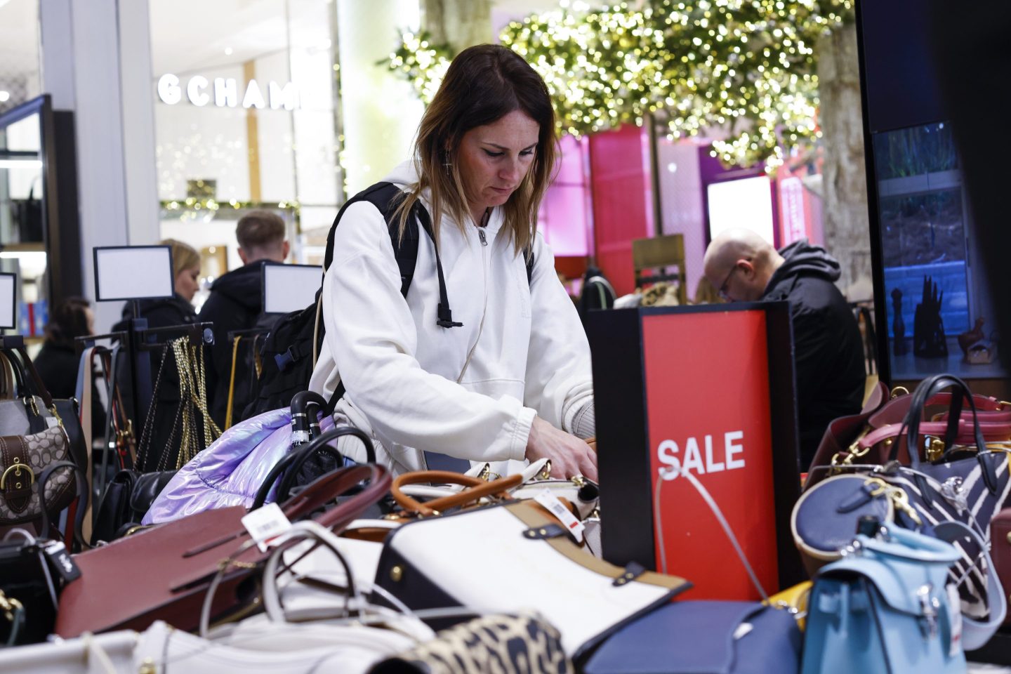 A poster displays reduction prices as customers visit Macy's Herald Square store on December 17, 2023 in New York City.