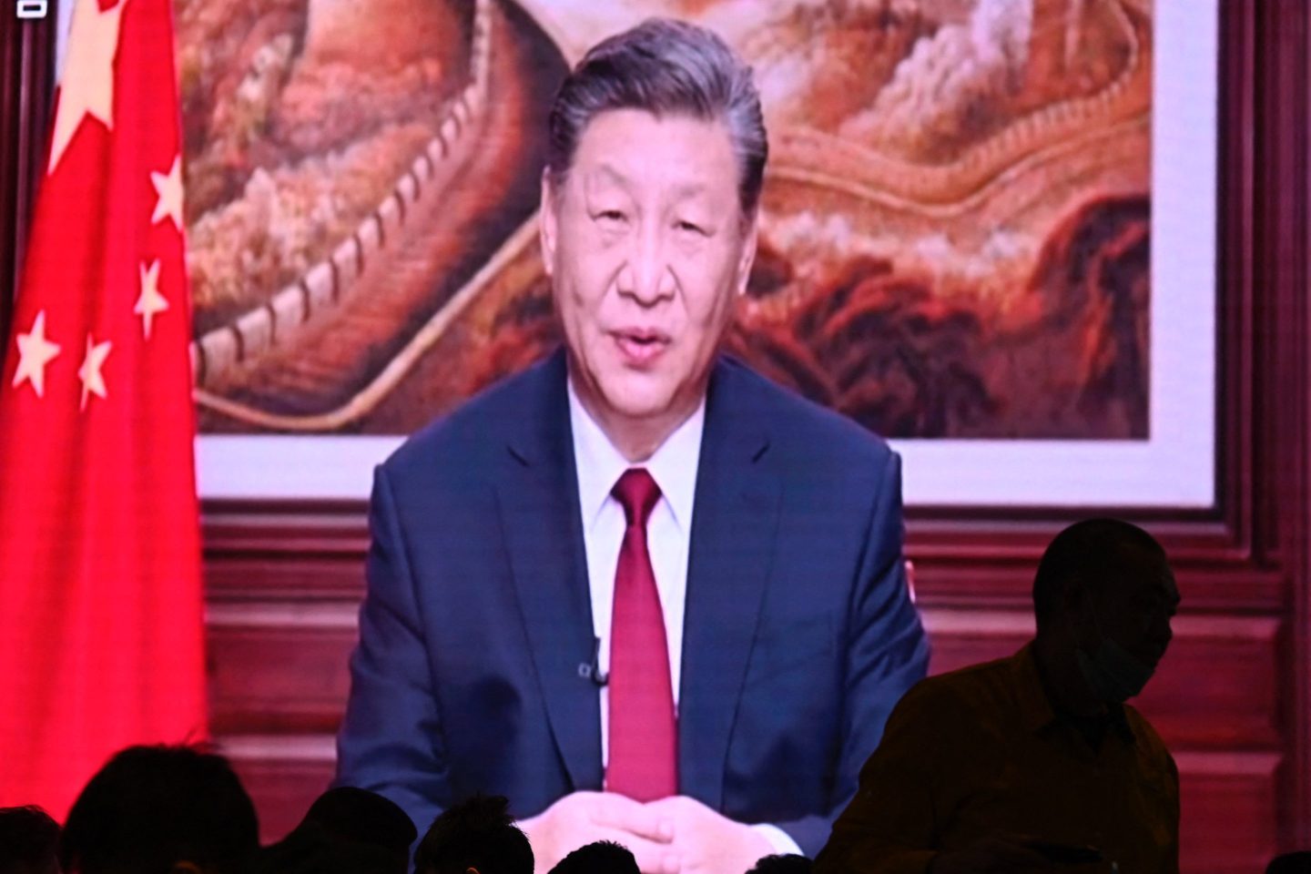 People have their dinner at a restaurant as a screen broadcasts China's President Xi Jinping while delivering his New Year's speech in Beijing on December 31, 2023.
