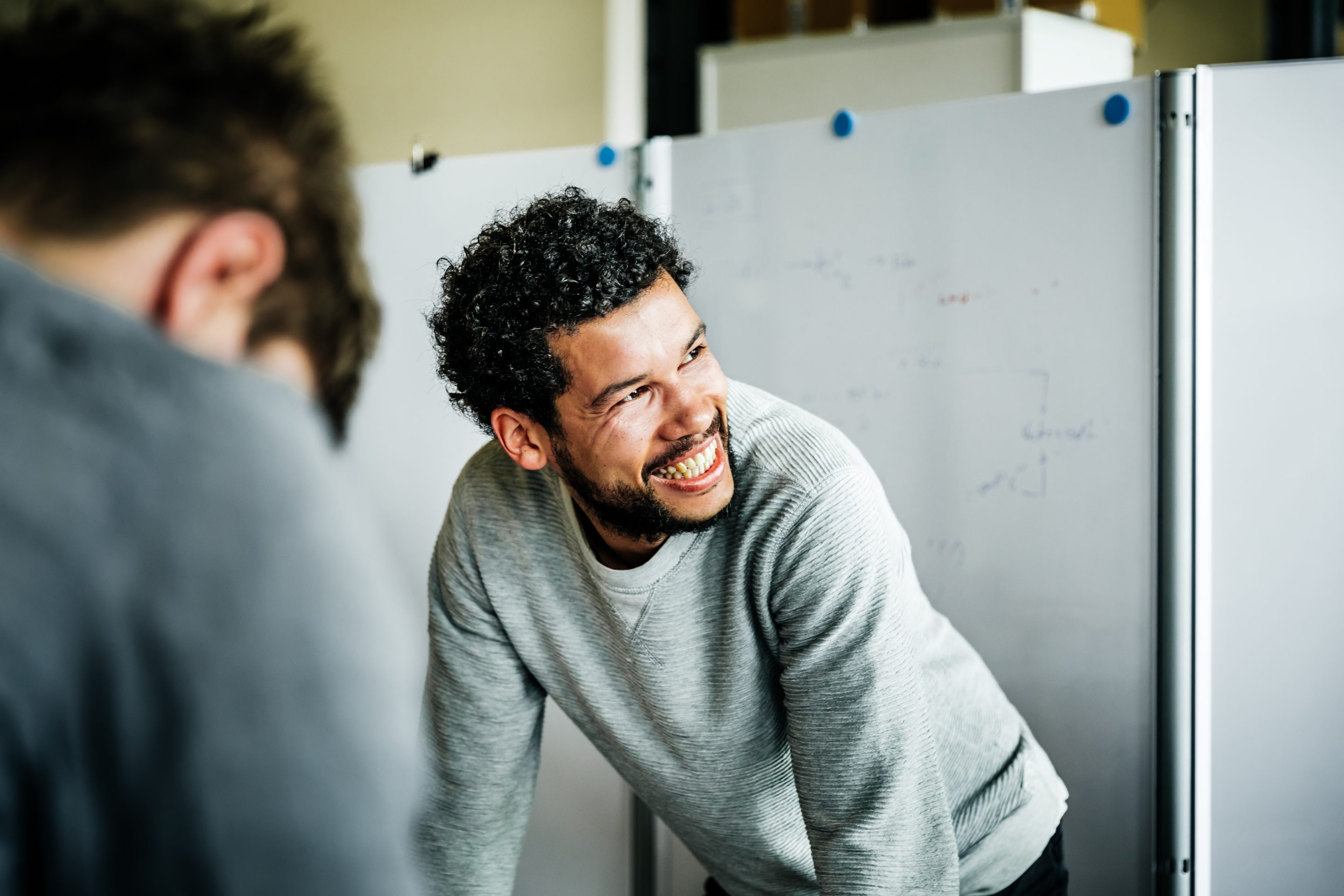 Portrait of a casual afro-american businessman during a meeting. He's smiling to his colleague