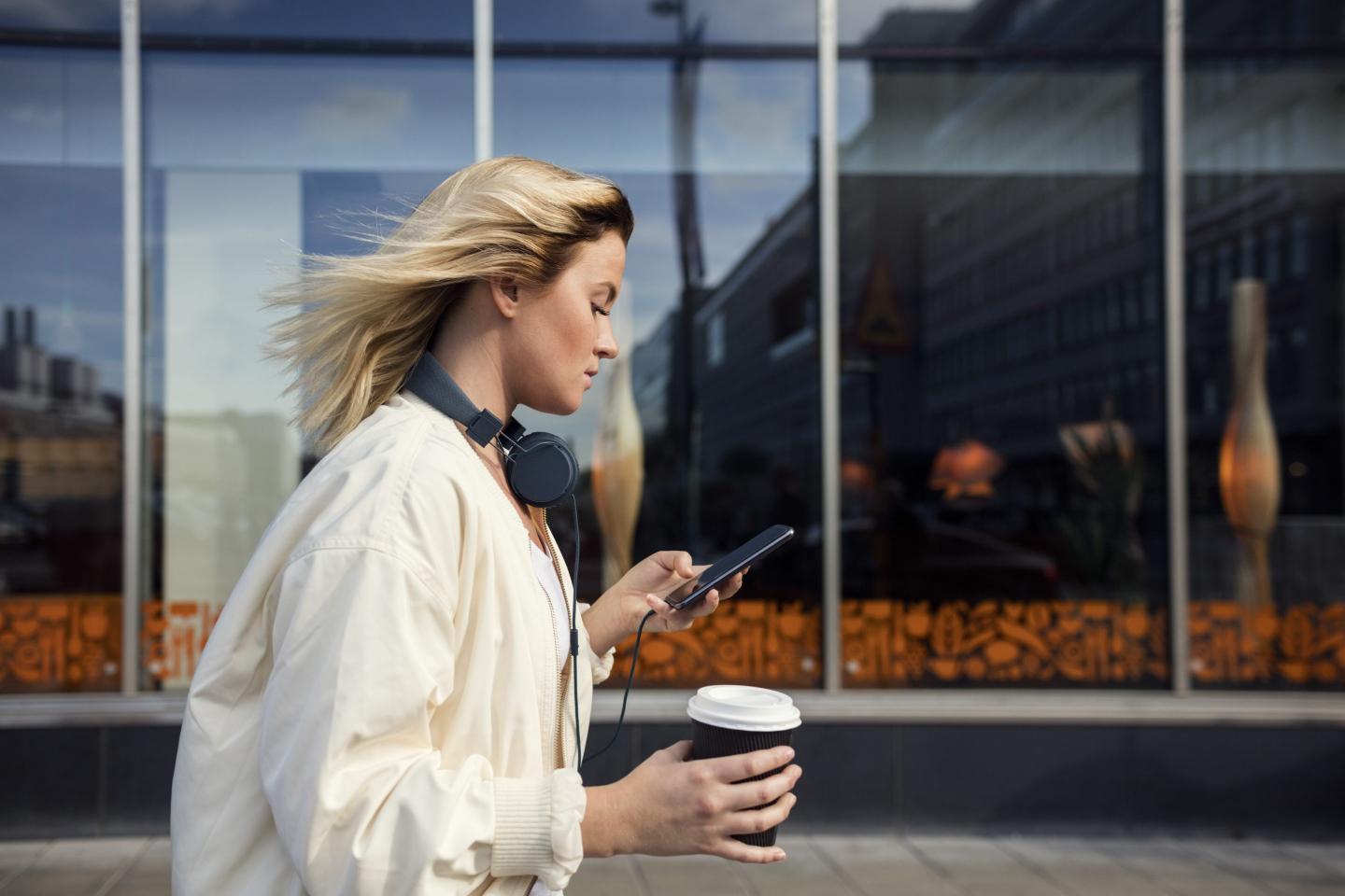 Woman using her phone and walking