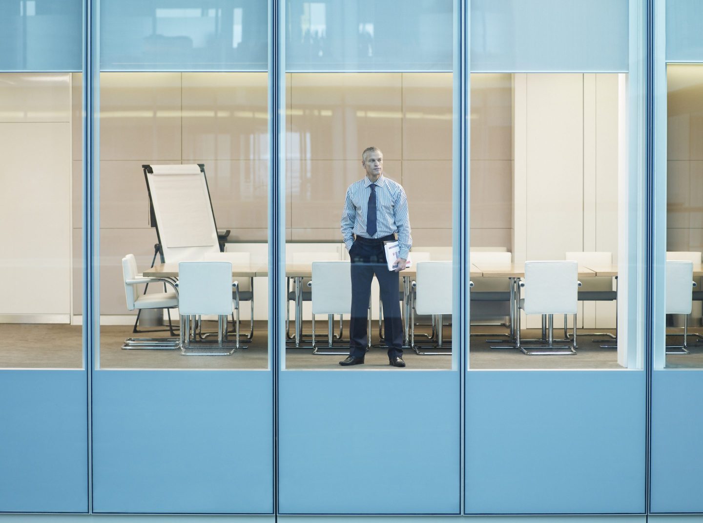 Businessman standing at window in conference room
