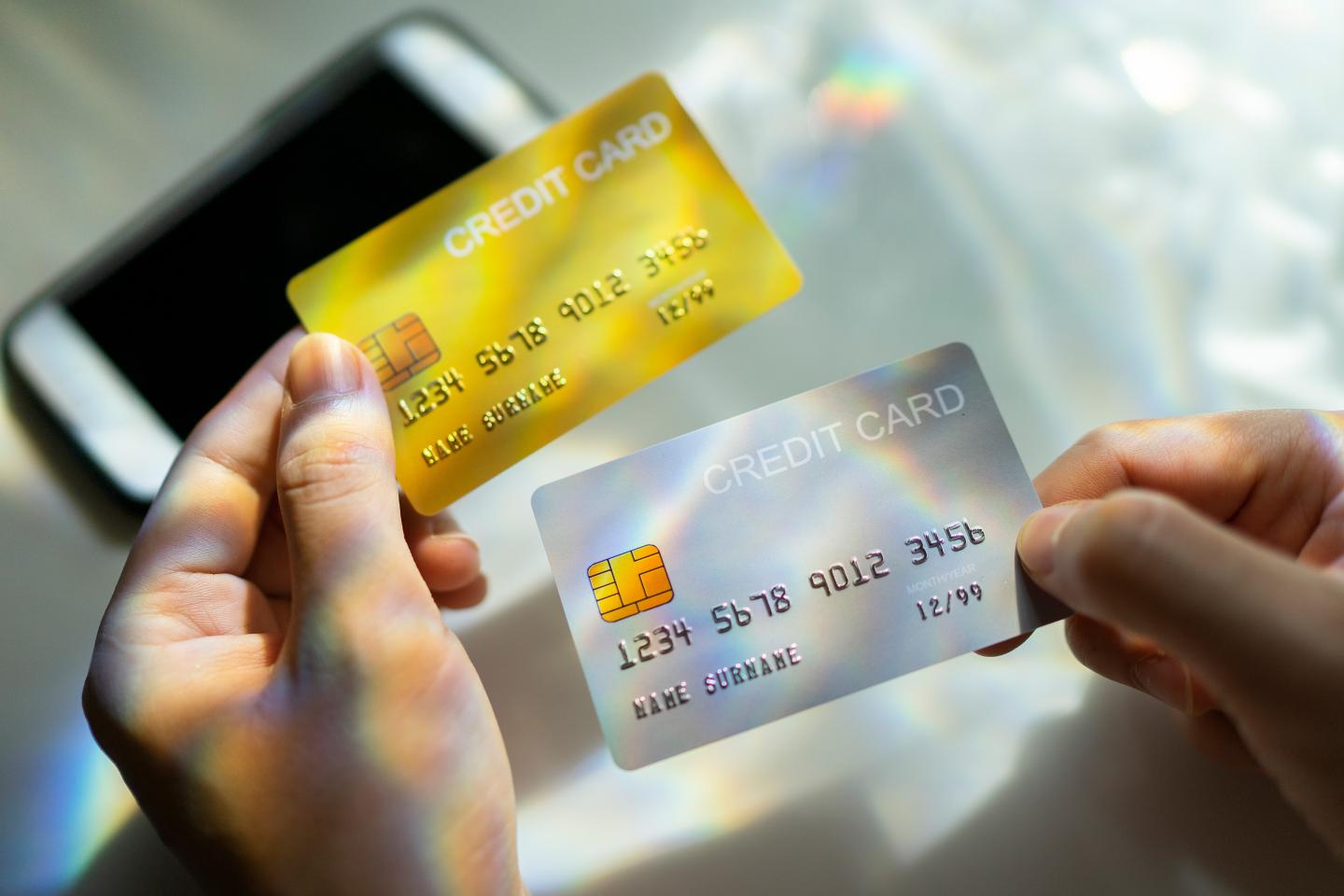 Close up of hand holding credit cards.