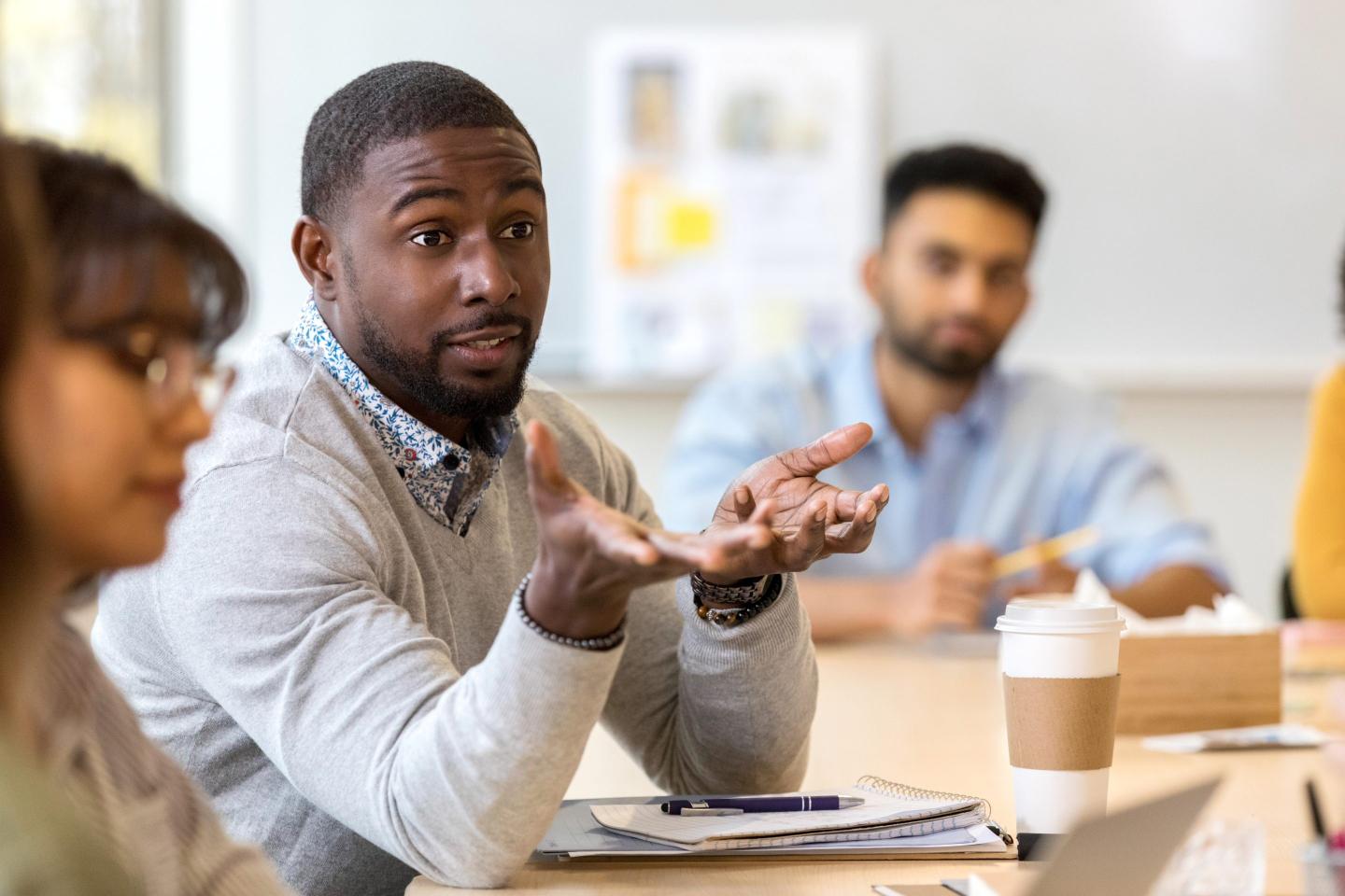 A young male professional sits at a conference table