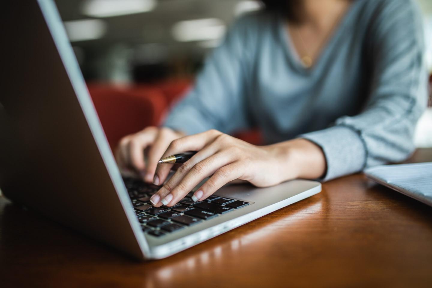 A female typing on a computer