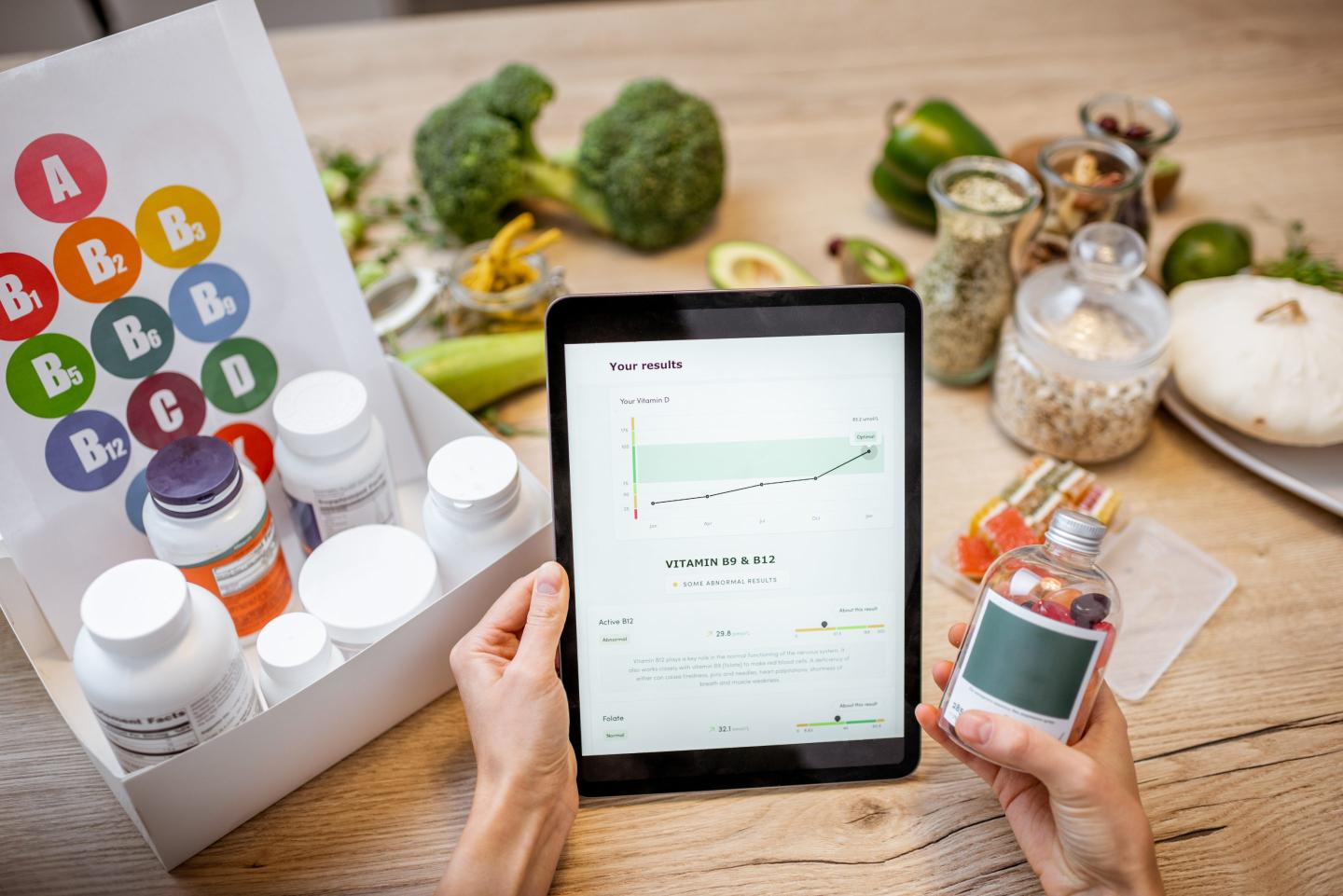 Woman checking the result of medical tests on a digital tablet, close-up with nutritional supplements on the background. Concept of individual online selection of food supplements