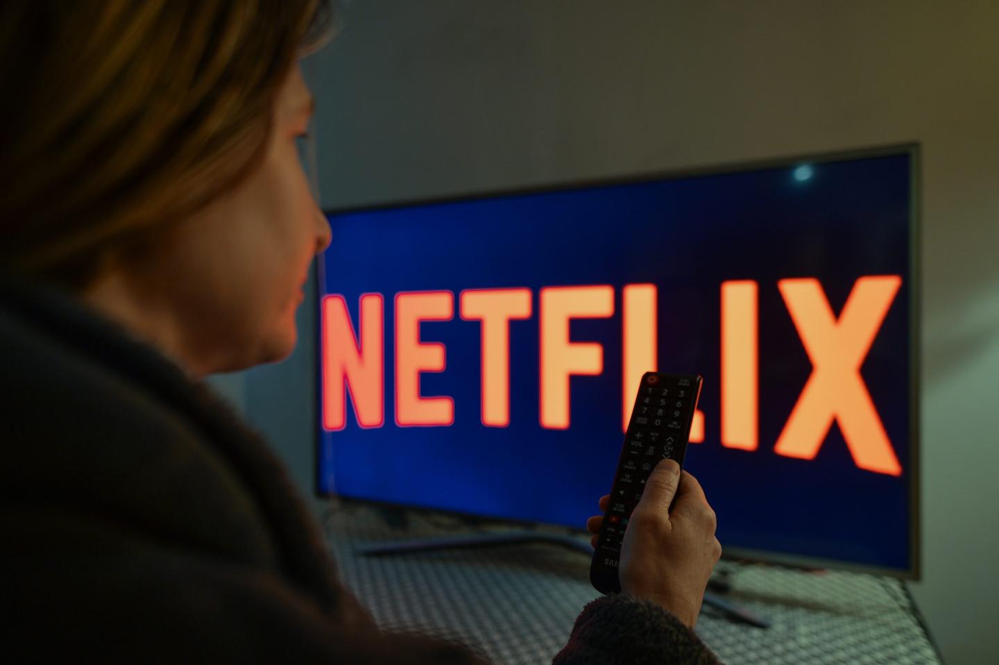 A woman watching Netflix on her tv