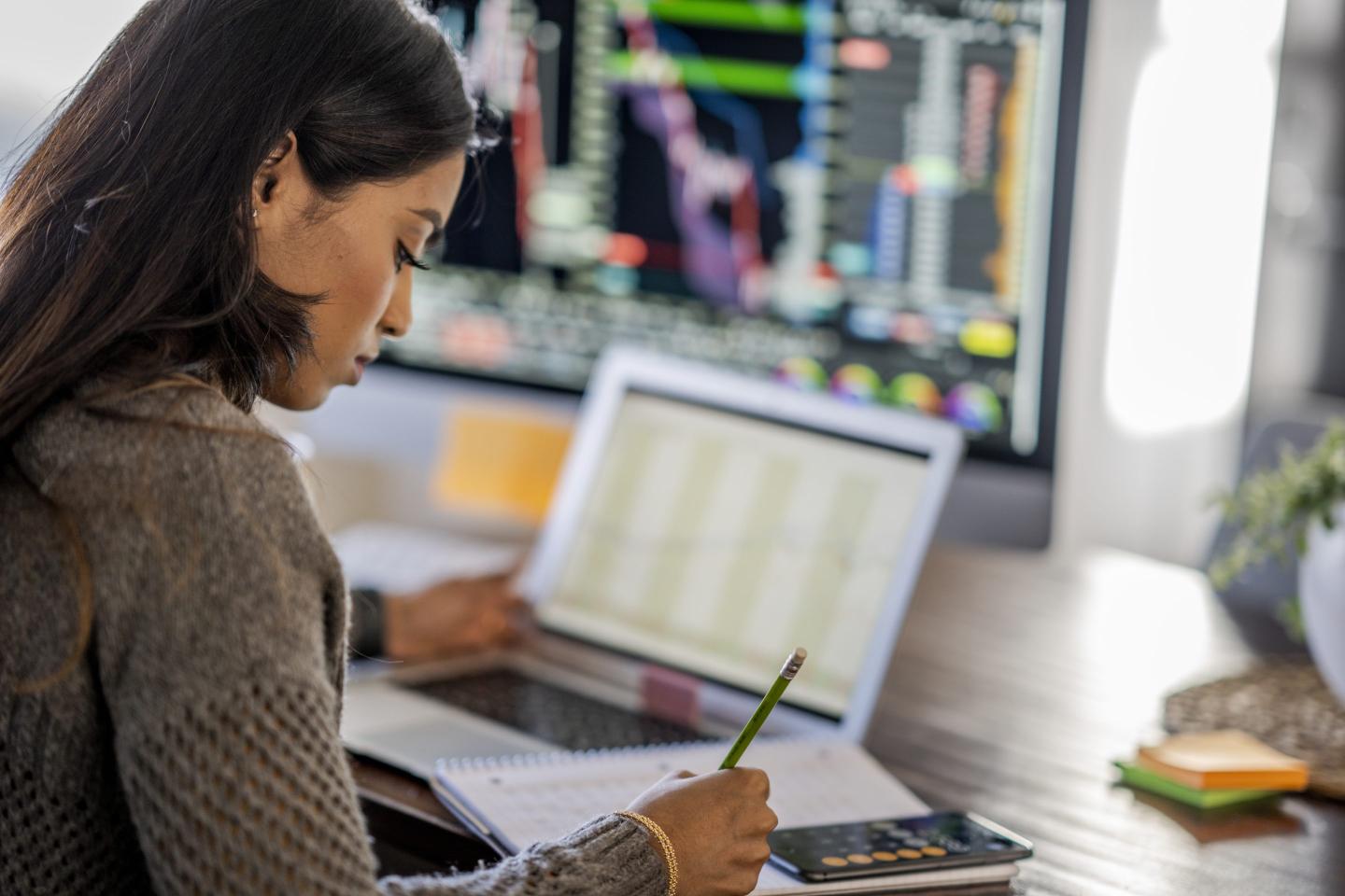 Young business woman takes notes from her laptop