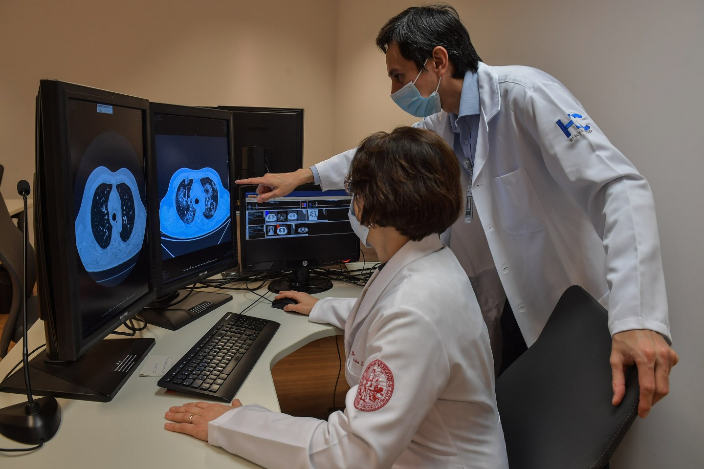 Researchers looking at lung scans on a computer screen.
