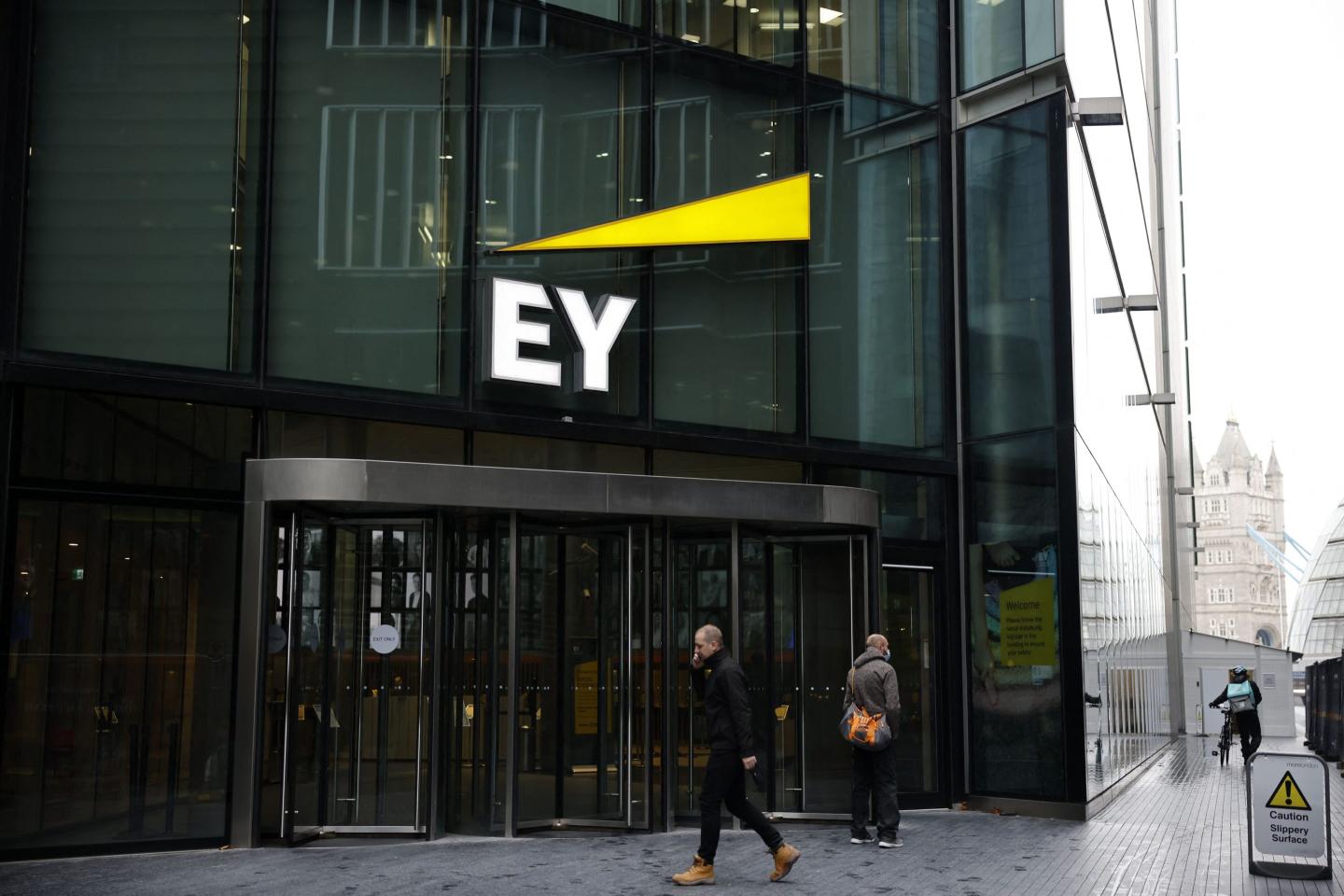 People walking past EY’s building in London