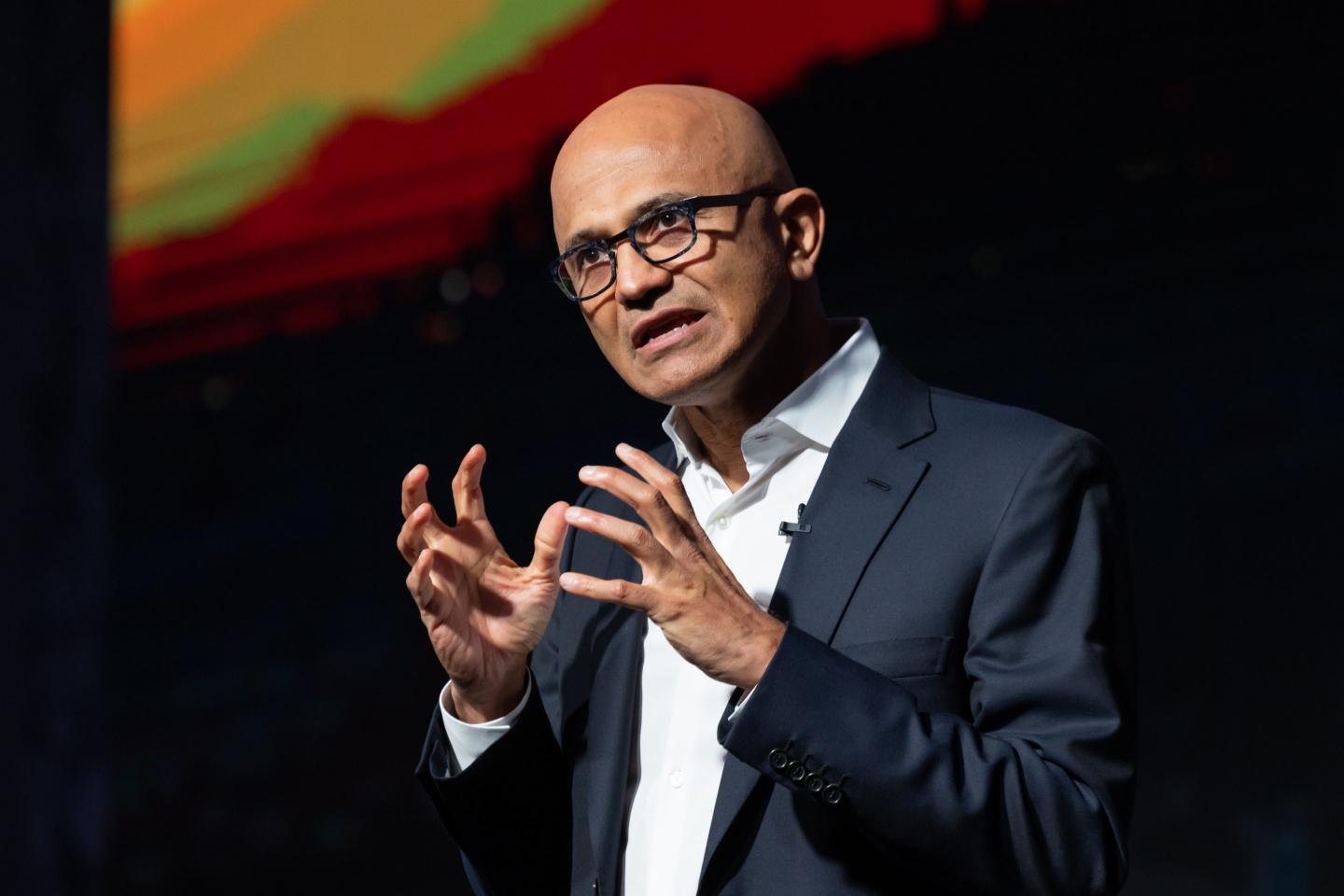 Microsoft CEO Satya Nadella gesticulates during an onstage presentation at a 2022 conference