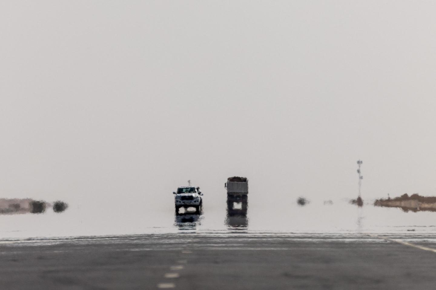 Cars traveling on a desert highway are engulfed in heat haze near Jaww Al Nasla in western Qatar on November 15, 2022.