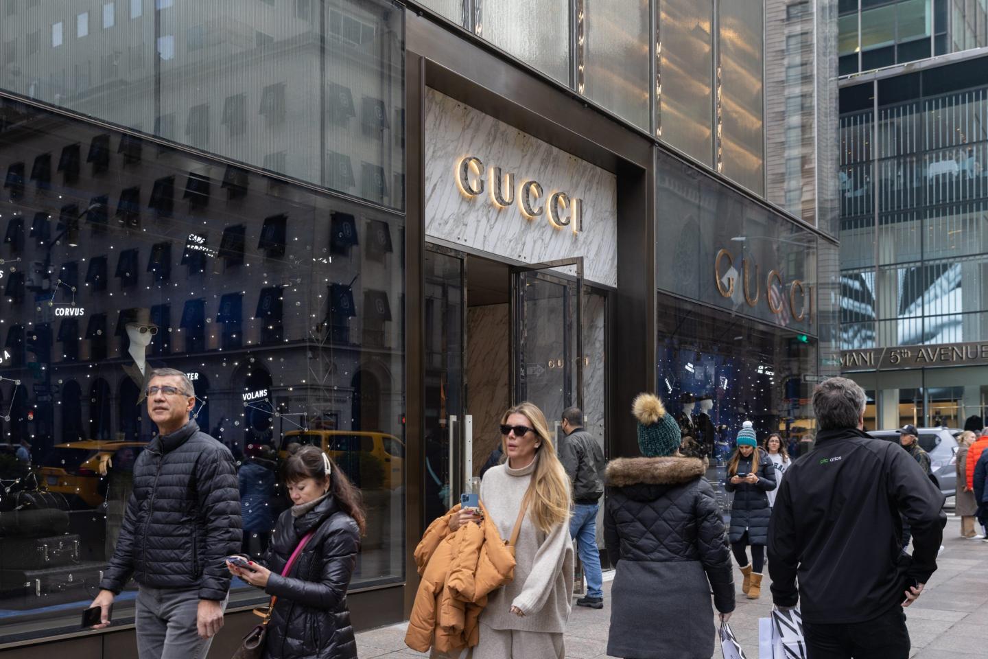 shoppers walking outside a Gucci store