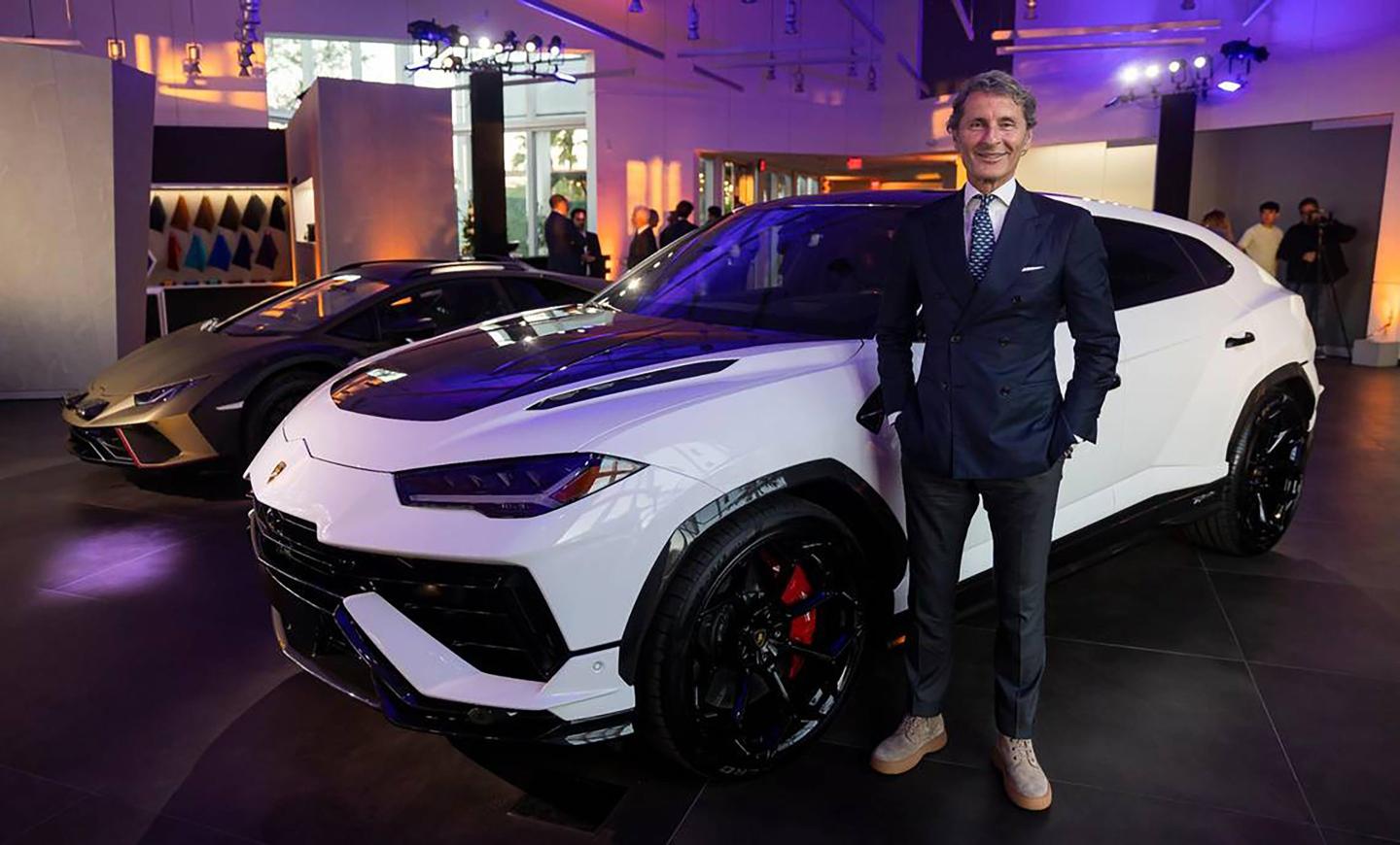 Lamborghini CEO Stephan Winkelmann standing beside a white Lamborghini car
