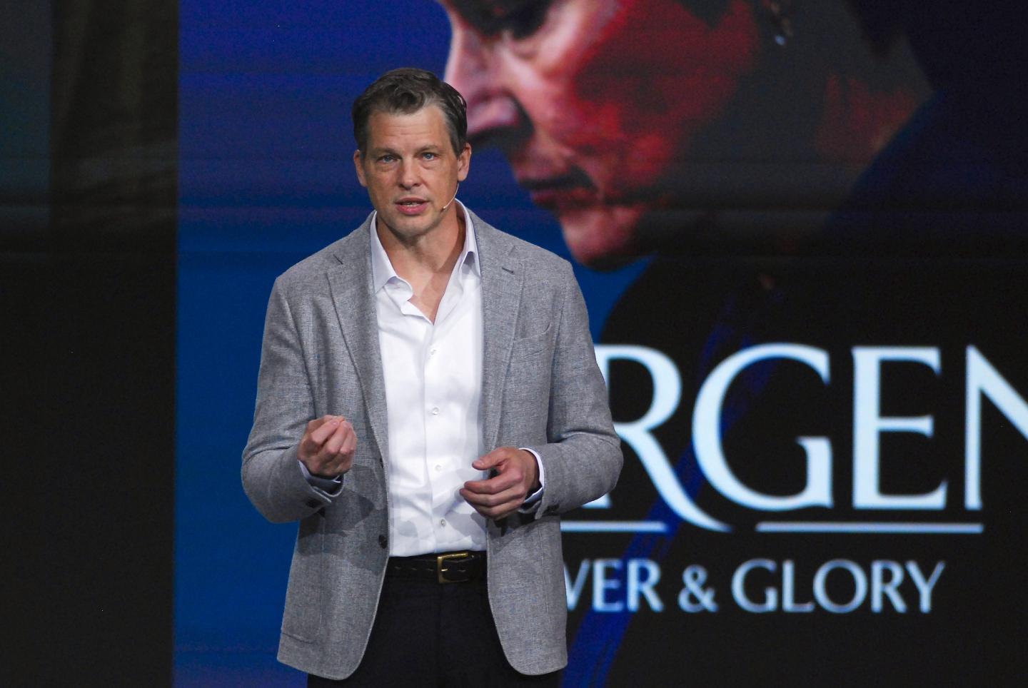 Greg Peters, Co-CEO of Netflix, speaks in front of a Netflix poster.