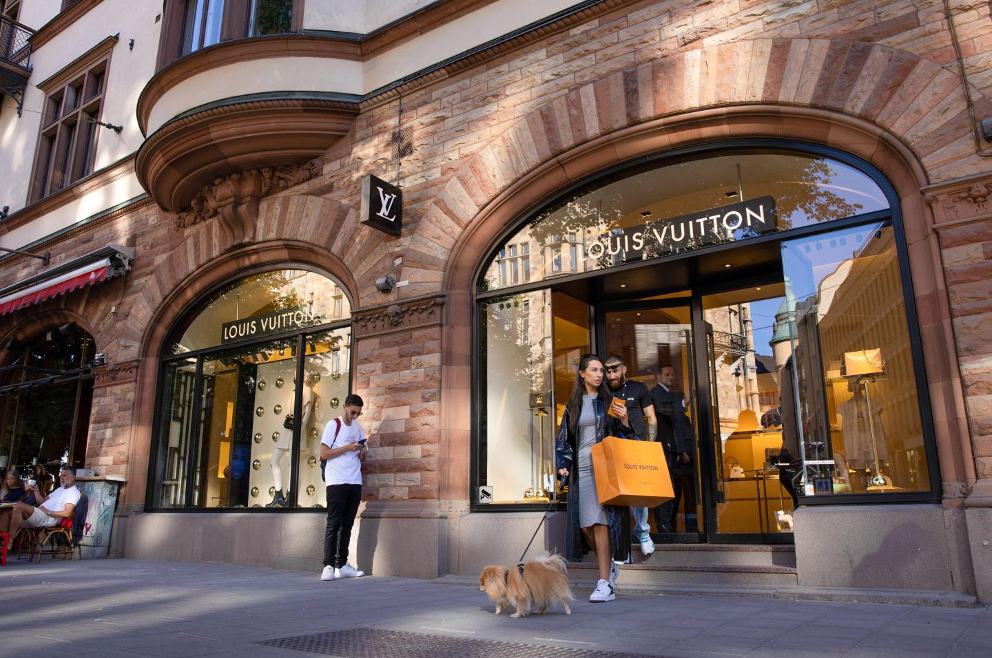 people walking out of Louis Vuitton store