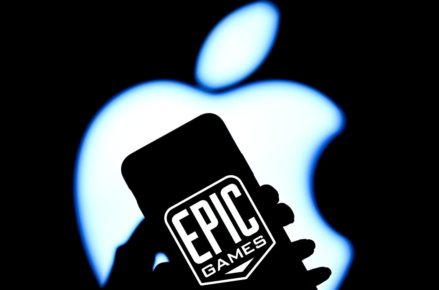 The logo of Epic Games is displayed on a mobile phone screen in front of the logo of Apple