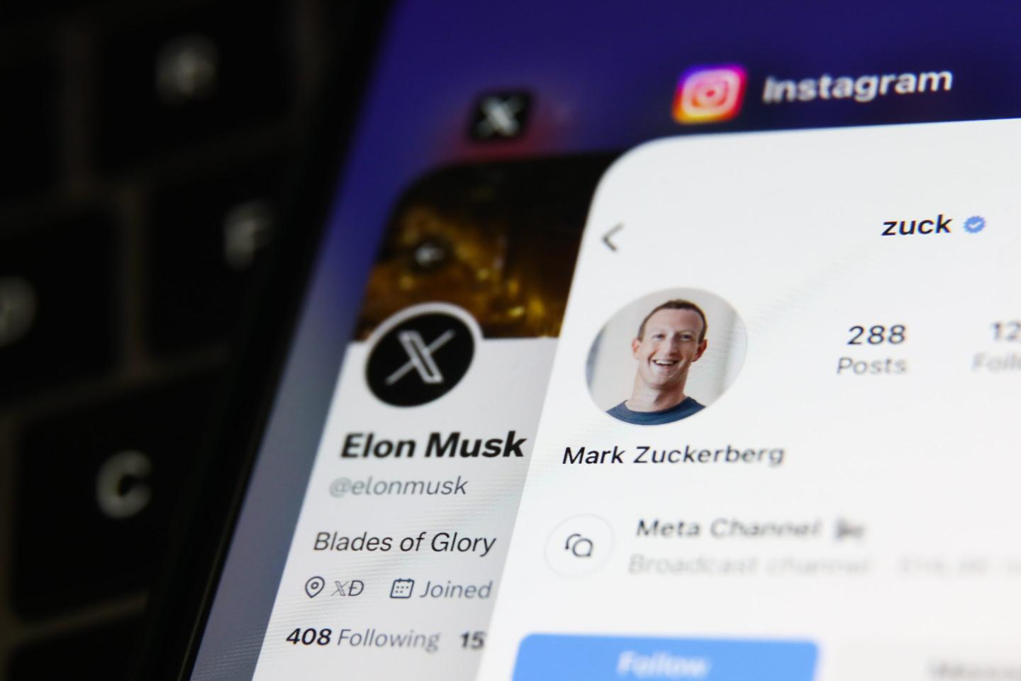 A laptop keyboard, Elon Musk account on X displayed on a phone screen and Mark Zuckerberg account on Instagram displayed on a phone screen