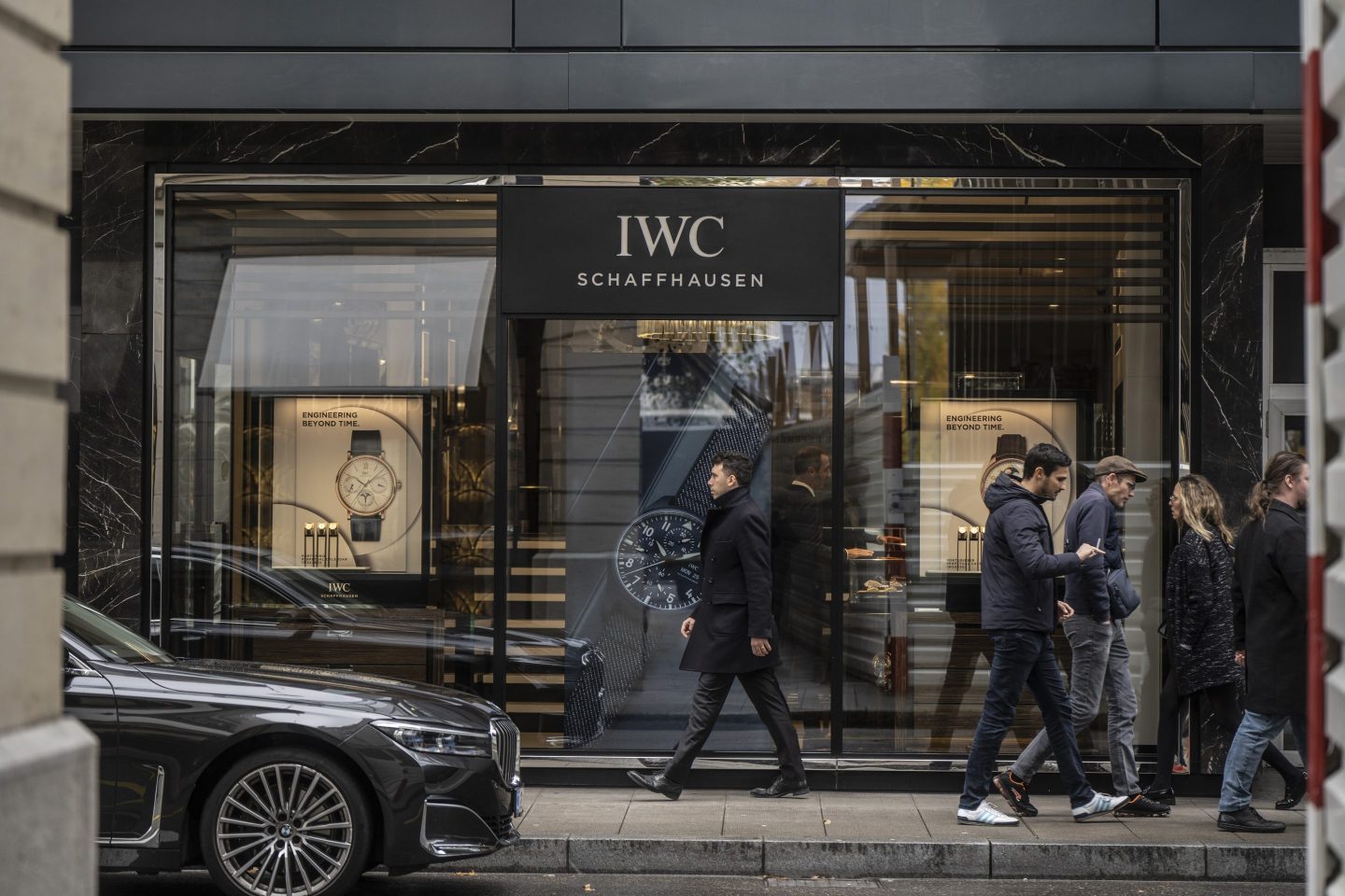 people walking outside an IWC store