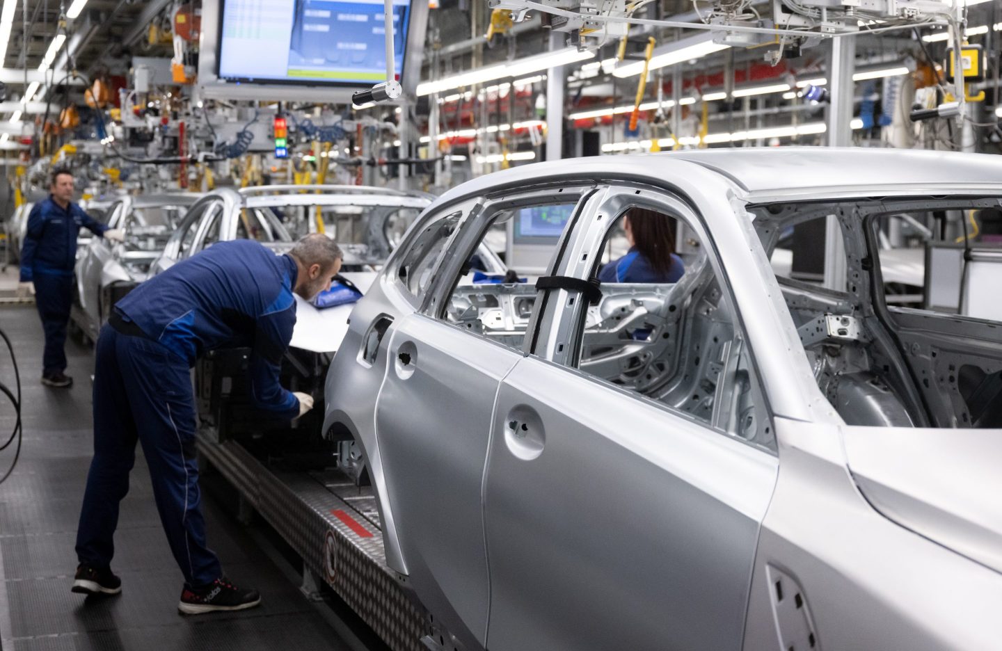 BMW employees work during a plant tour by Chancellor Scholz (SPD) in December 2023. BMW group EV sales jumped 75% last year, driven by models like the i4 sedan.
