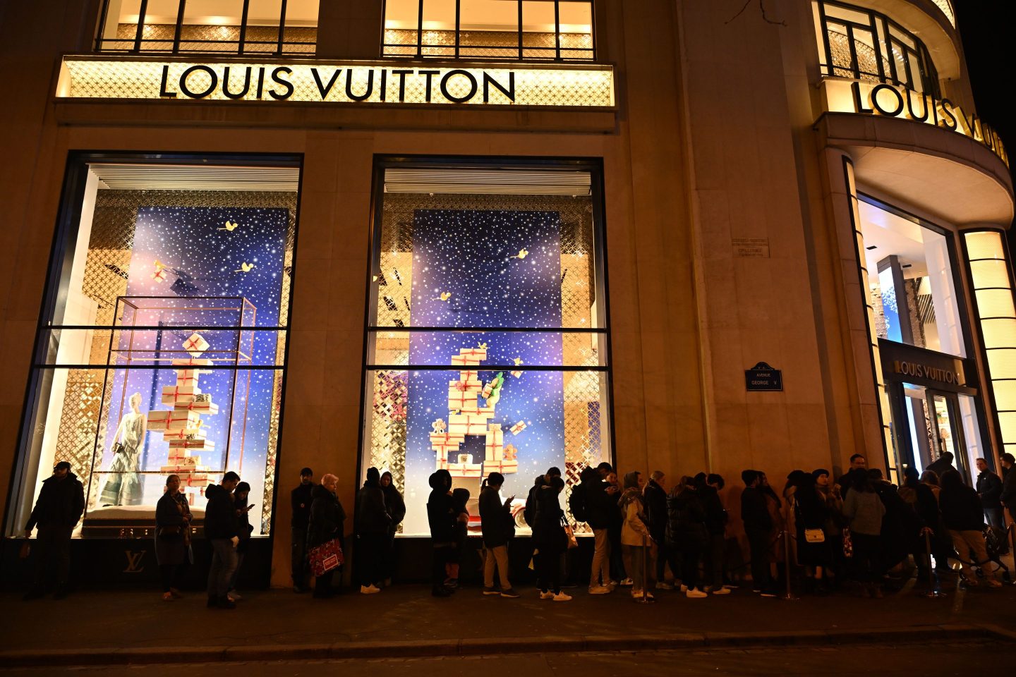 people queuing outside a louis vuitton store