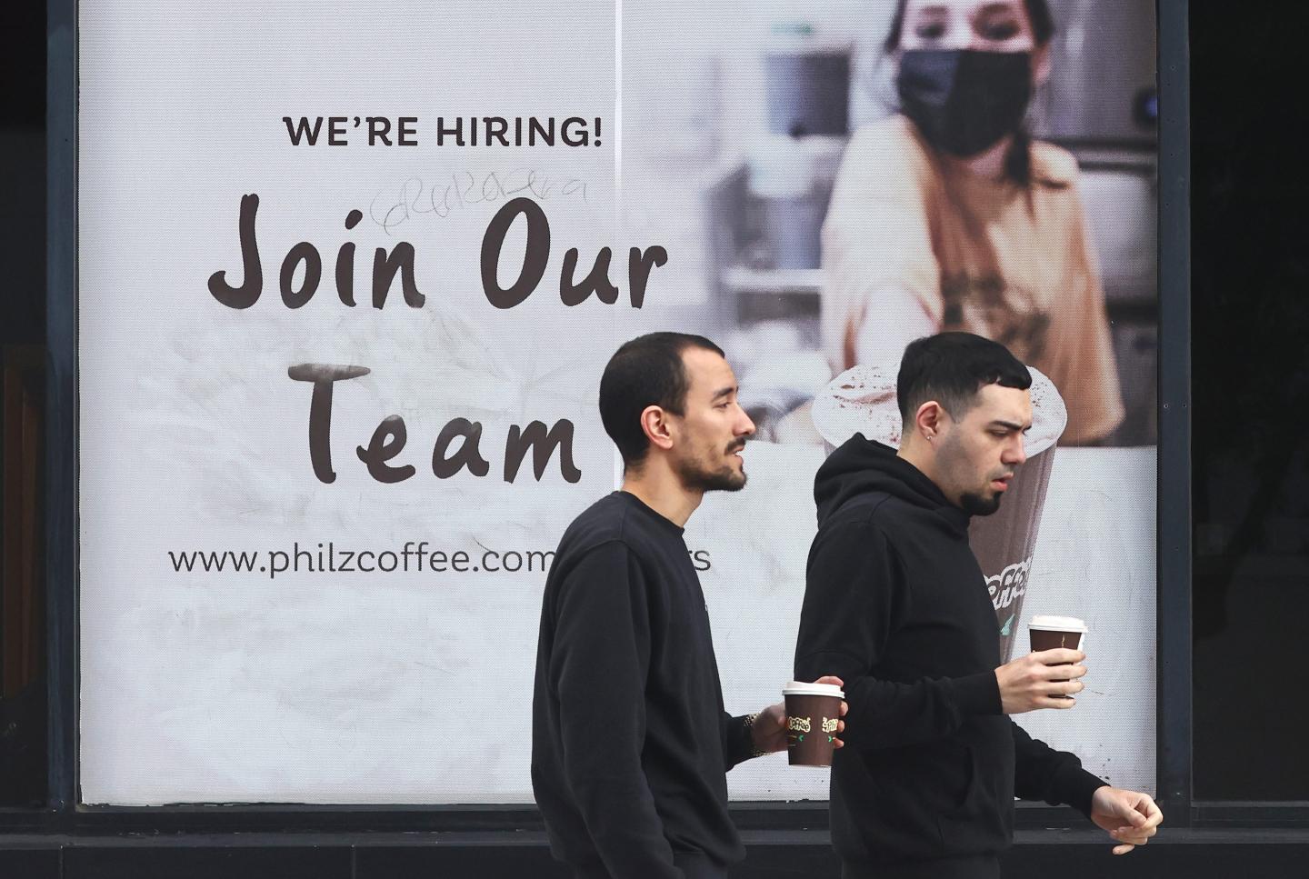 A 'Join Our Team' sign is posted outside a coffee shop