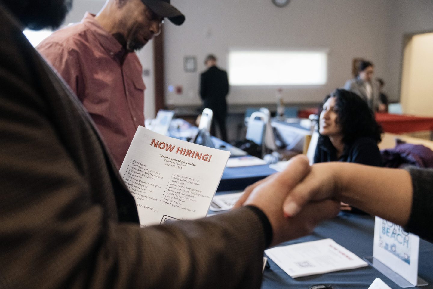 Attendees shake hands at a Veteran Employment and Resource Fair in Long Beach, California on Jan. 9, 2024.