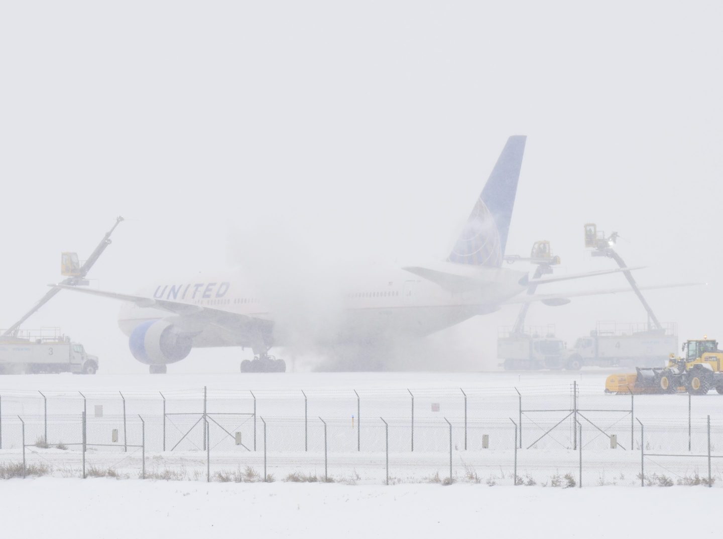 Crews work to deice an airplane at Denver International Airport in Denver, Colorado